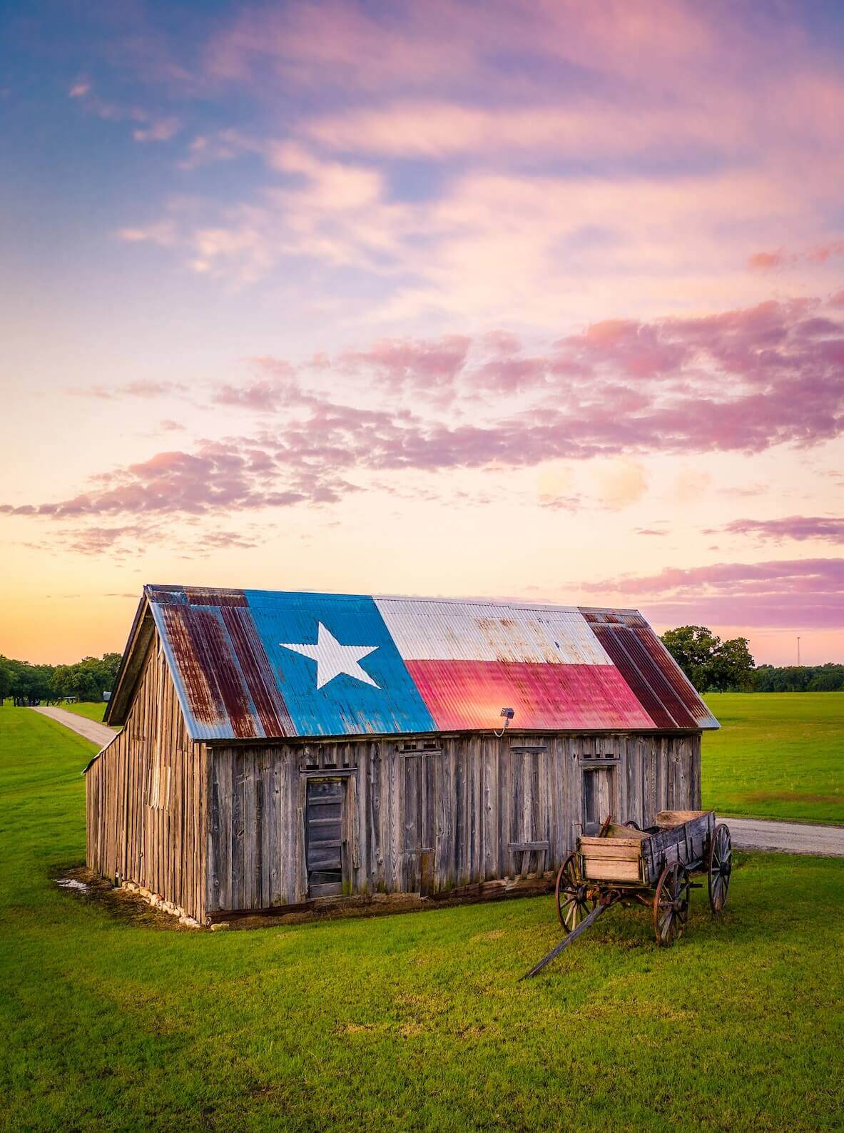 Weathered barn with a Texas flag roof at sunset